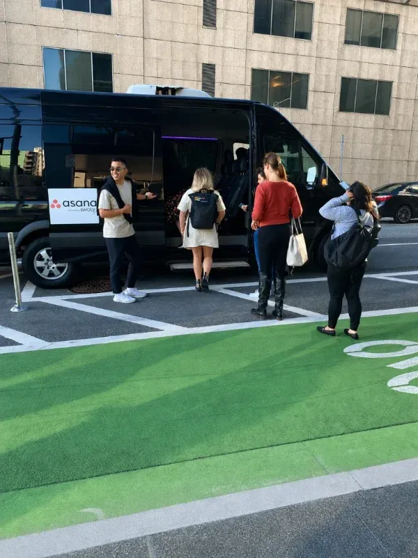 Guests boarding a black shuttle van in a parking lot