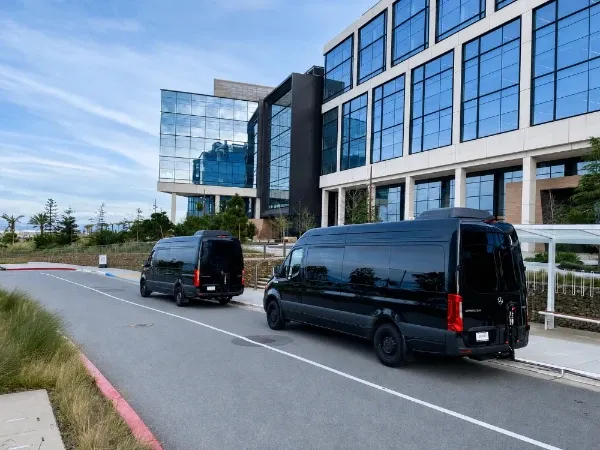Black Sprinter vans parked outside an office campus