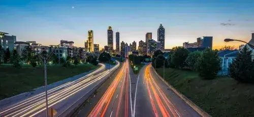 Downtown Atlanta skyline with light trails on the highway at dusk
